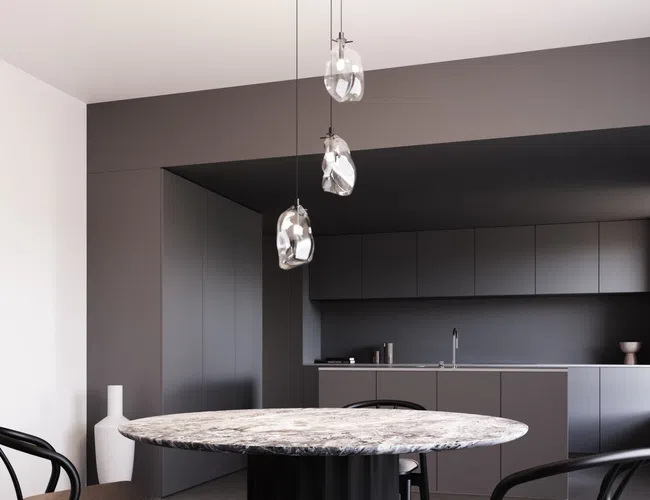Modern kitchen with dark gray cabinetry, round marble table, and pendant glass light fixtures in minimalist design.
