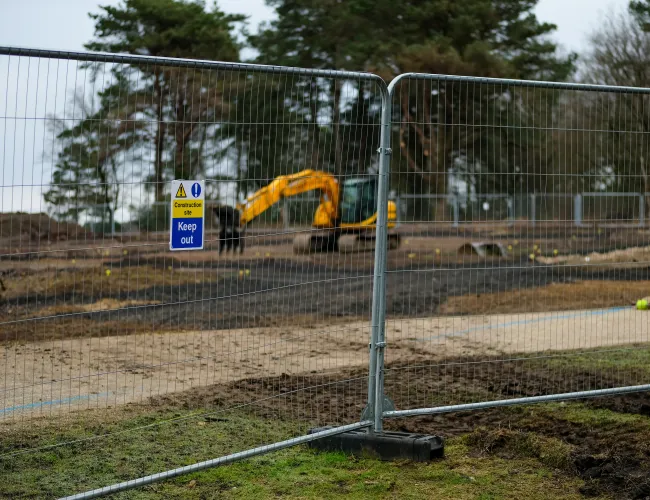 a yellow truck behind a fence
