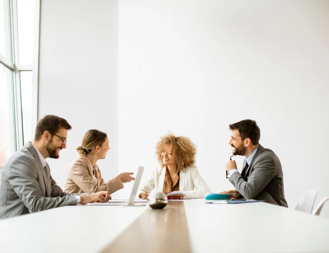 a group of people sitting at a table looking at a paper