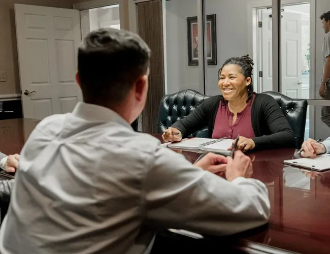 Business meeting with diverse team discussing ideas around a conference table in a bright office space