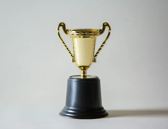 a gold trophy on a black stand