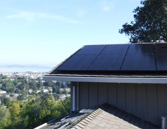 a roof of a building with trees and a city in the background