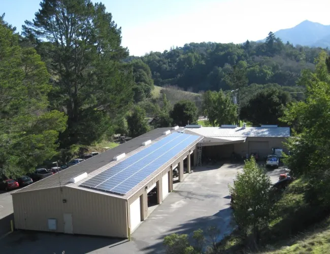 a building with a parking lot and trees in the back