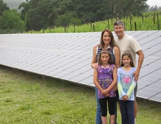 a group of people standing in front of a solar panel