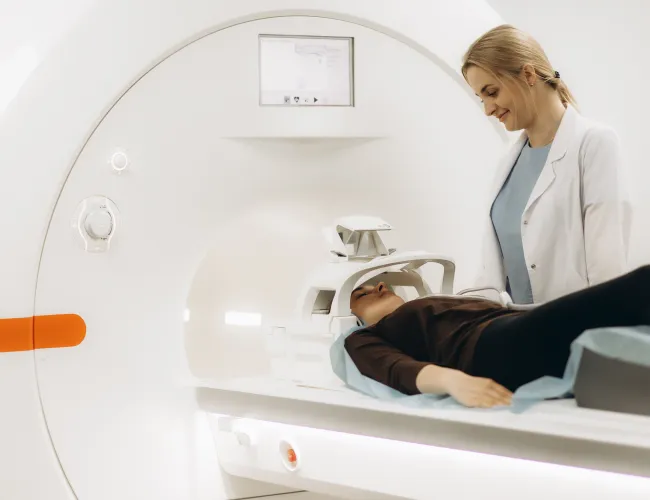 A medical professional assists a patient during an MRI scan in a modern facility.