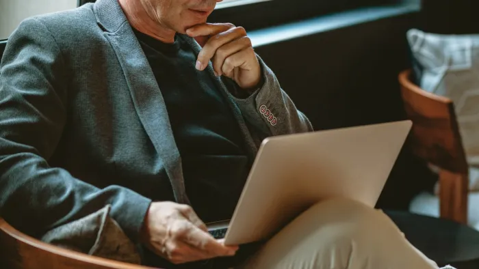 a man sitting at a table using a laptop