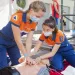 a group of people in blue jumpsuits working on a patient