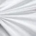 Soft white fabric with smooth folds and subtle texture arranged in a fan-like pattern