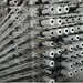 Rows of white thread spools with threads organized on a textile manufacturing machine in a factory.