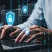 Person typing on laptop with digital padlock icons representing cybersecurity and data protection concepts.