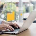 Person typing on laptop with digital folder icons and interface overlays representing file management software.