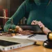 Person using a tablet at desk with legal scales, gavel, laptop, and notebook in a law office setting.