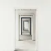 Series of white doorframes creating a symmetrical, infinite hallway perspective in an empty room.