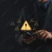 Businessman holding phone with multiple yellow warning signs and exclamation marks on black background