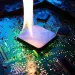 Flame rising from a computer processor chip on a blue circuit board indicating overheating or damage.