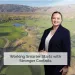Professional woman smiling in business suit with golf course and mountains background