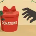 Red donation box decorated with holly and bow, hand reaching out, festive string lights in background.