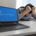 a man with a mask on his face looking at a laptop