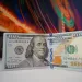 $100 bill with Colorful Background on a computer screen showcasing the financial cost of bad cybersecurity.