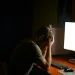 a person sitting at a desk with the head in the hand