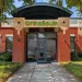 Entrance of OrthoSouth building with glass door, brick walls, greenery, and a curved black awning under a clear blue sky.
