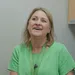Smiling woman in a green shirt and OrthoSouth lanyard talking in an office setting
