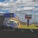 Pirtek service van parked outside customer service building with Pirtek welcome sign under blue sky with clouds
