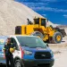 PIRTEK service van and worker with helmet in front of yellow loader at gravel site under blue sky
