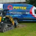 Pirtek mobile hose service van parked on grass next to a yellow ASV RT-50 compact track loader.