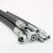 Set of black hydraulic hoses with silver metal fittings on white background
