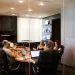 a group of people sitting around a table with laptops