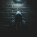 a person wearing a hoodie and a hat in a dark room
