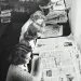 a group of women looking at a newspaper