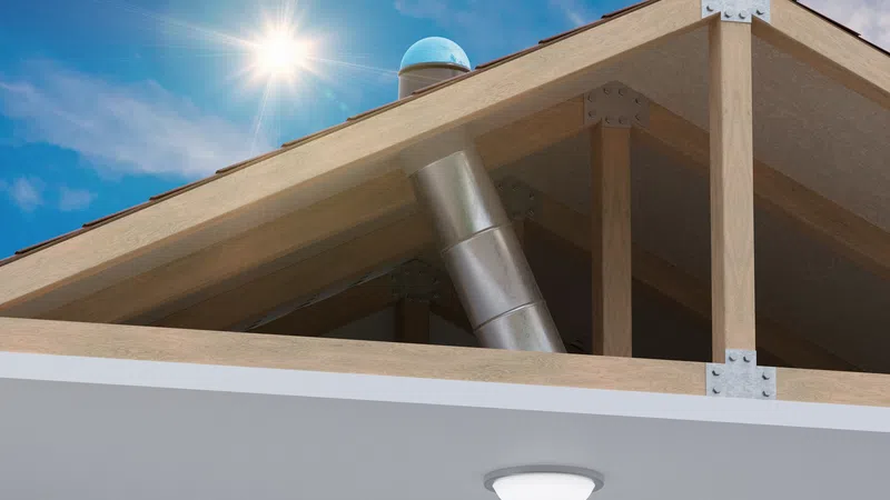 Wooden roof structure with metal chimney, sunlight, and blue sky in the background