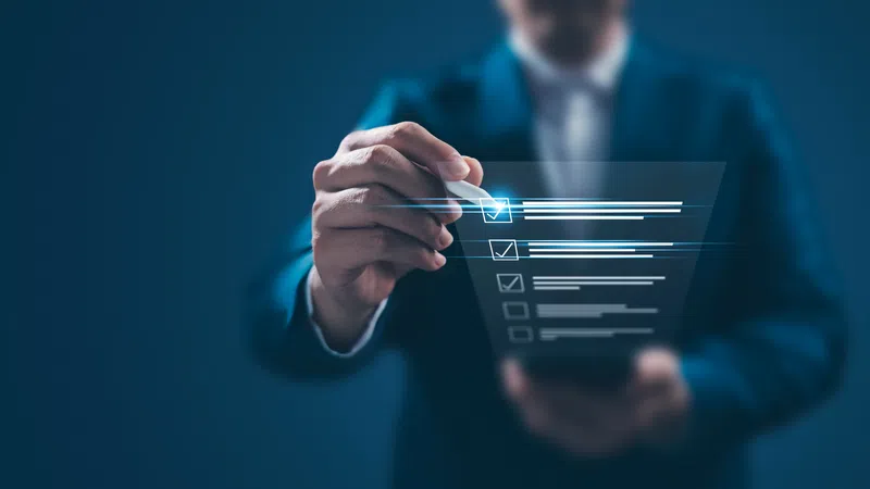 Businessman in suit selecting options on a transparent digital checklist interface with a futuristic blue glow.