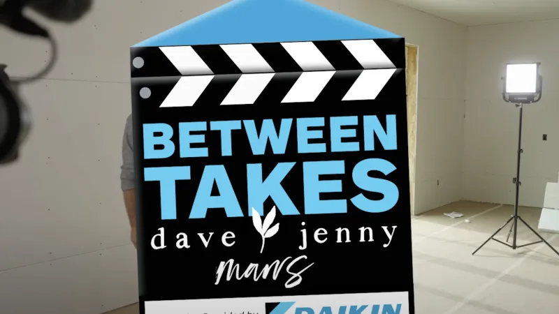 Film clapperboard with Between Takes Dave Jenny Mans logo and Daikin expertise, in a studio with lighting and boom mic.