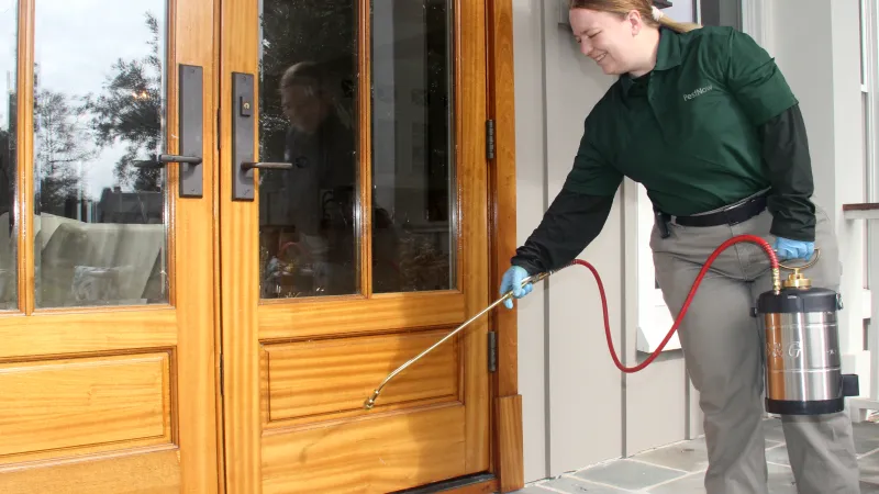 a person holding a hose to a door