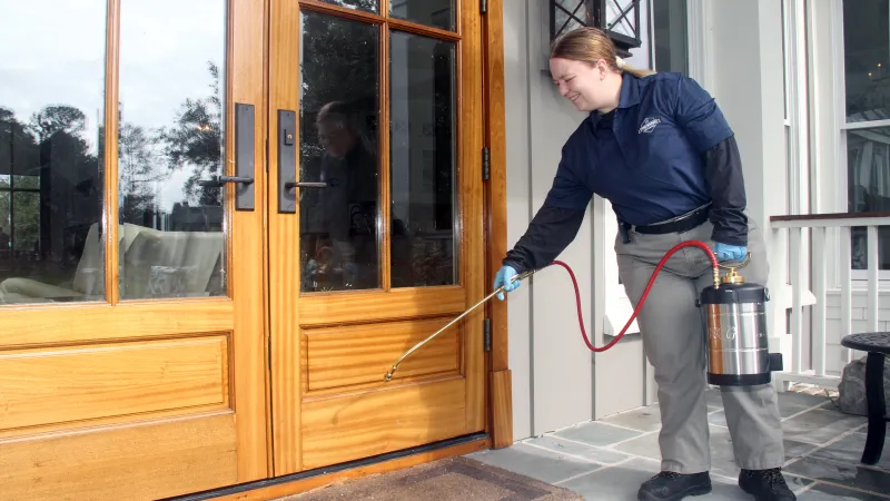 a person holding a hose to a door