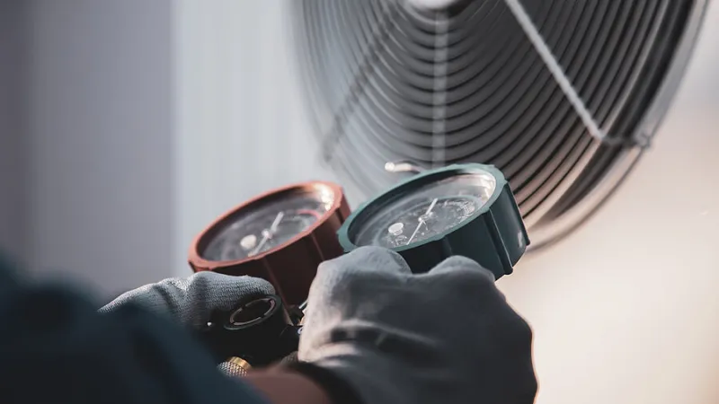 a pair of hands wearing black watchesWarning Signs Your HVAC Needs Replaced