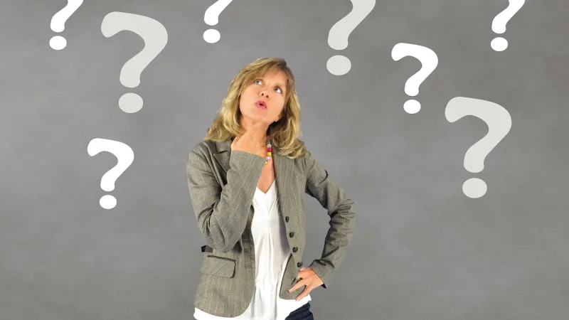 a woman standing in front of a blackboard with white letters