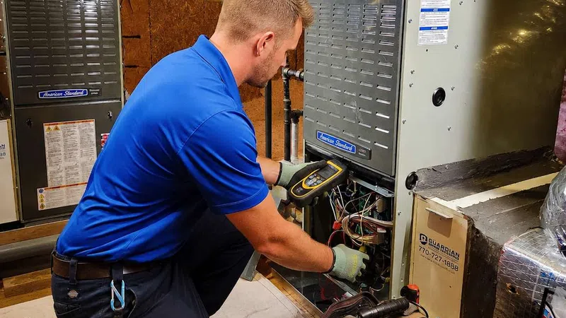 Technician in blue shirt repairing HVAC system with tools in an attic workspace