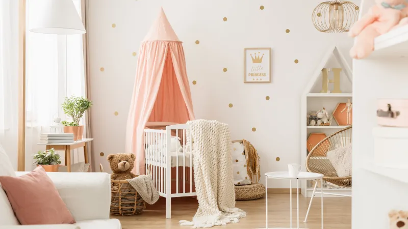baby nursery with white chair with a pink curtain