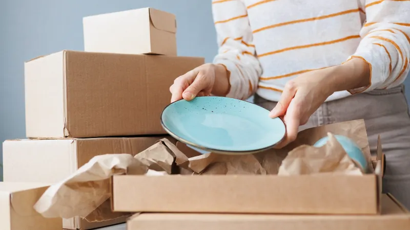 woman packing dishes for storage