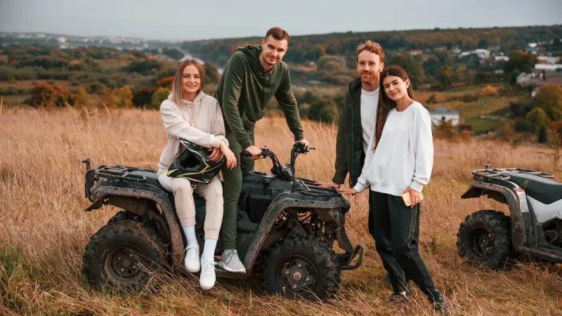 two young couples in a field with their ATV from storage