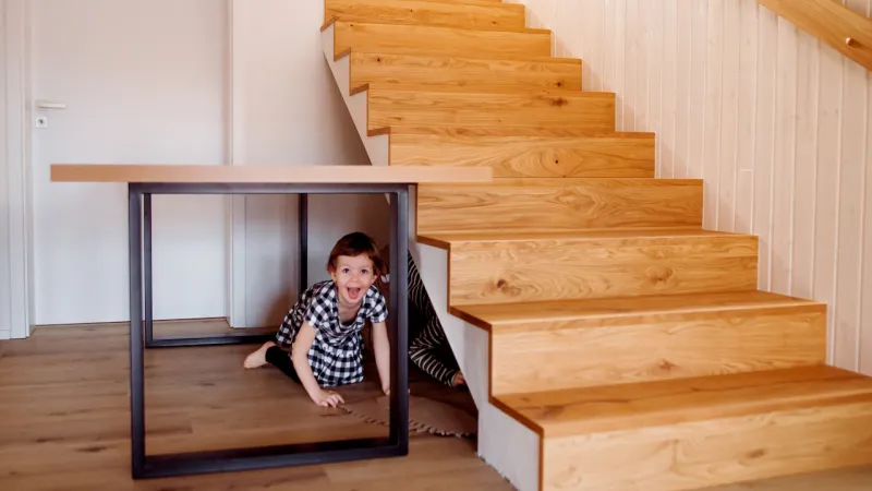 a child playing in a space for under stairs storage