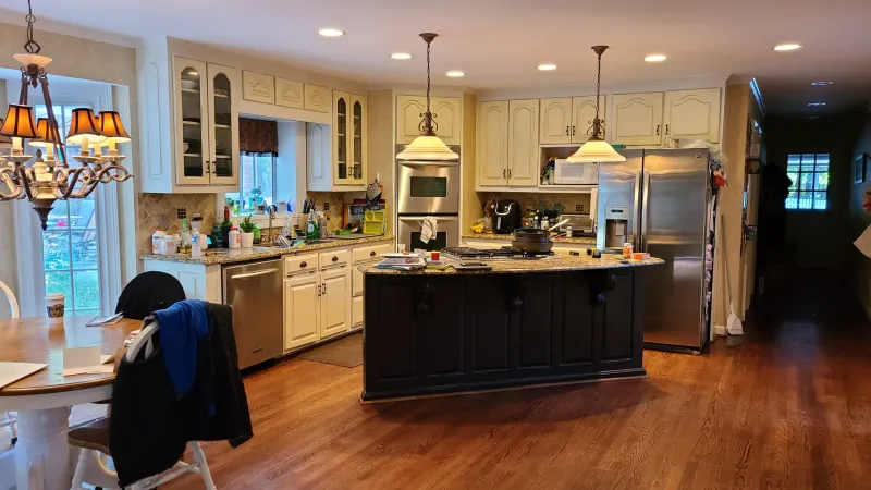 an old, yellow kitchen with an island in the middle of a room