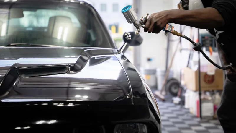 a person filling a car with a hose