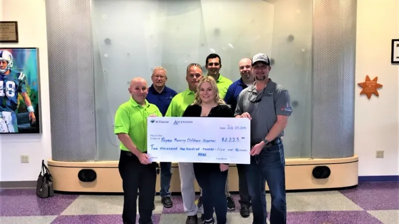 Roof It Forward presenting a check to the Peyton Manning Children's Hospital in 2018.