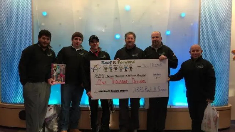 Roof It Forward presenting a check to the Peyton Manning Children's Hospital in 2015.