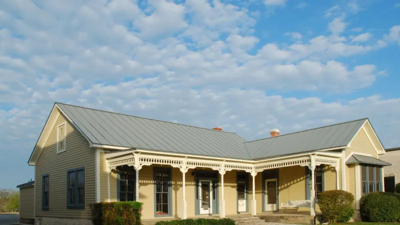 a large brick building with grass in front of a house